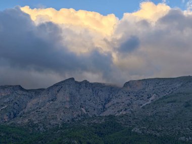 Güneş Işığı Dağları Parlayan Bulut Tacı Altında, Yumuşak Altın Işıklar Kayalık Tepeler ve Uzakta