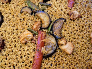 Kabak ve pilavlı Paella, ızgara kabak dilimleriyle işlenmiş altın sarısı safra tohumu.,