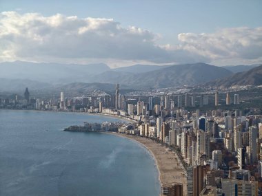 Ruh hali, karamsar şehir manzarası, kıyı manzarası otellerin ve plajların üzerinde bulutlu gökyüzü.