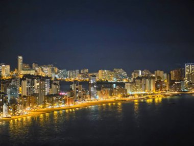 Geniş Rıhtımlı Ufuk Çizgisi Aydınlatılmış Sahil boyunca uzanan, Süreklilik Yansıtan Altın Işıklar