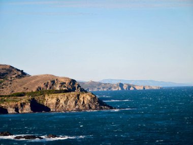 Kapsamlı Okyanuslara ve Uzak Burunlara Bakan Güneş Işıklı Promontuar Engebeli Konutları Ilık Hafif Vurguluyor