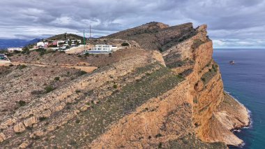 Kayalık Dağ Kıyısı ve Tuğlalı Binalar Mavi Deniz 'e Düşen Dikenli Uçurumlar,