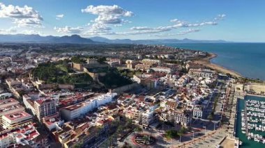 Sunlit Sahil Kasabası Marina 'yla, Hilltop' taki Tarihi Kale ve Beyaz Binalar Kıyıya dökülüyor, Parlak Mavi