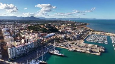 Yoğun liman ve liman manzarası, yatlar ve yelkenlilerle dolu turkuaz havza, kafelerle dolu rıhtım.