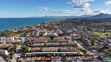 Havuz ve ağaçlarla çevrili caddeleri, Turkuaz 'a doğru yuvarlanan sahil şeridi