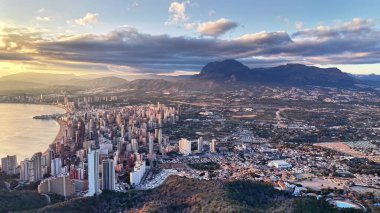 Panoramic Urban Expanse With Mountain Backdrop, Drone Glide Revealing Dense Highrise Clusters, Winding Roads,