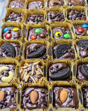 Kağıt bardaklara dizilmiş mini çikolatalı brovniler çeşitli fındıklar (badem, kaju) ve renkli şeker malzemeleriyle sergilenmektedir. Zengin, tatlı ve popüler bir Tayland sokak tatlısı..