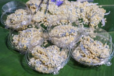 Kanom Tua Paep (Soft Mung Bean Crepe), a colorful Thai traditional dessert tinted with Butterfly Pea flower. This sweet street food is packaged for takeaway.