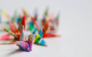 Renkli origami vinçlerinin sığ alan derinliğine yakın açıyla yerleştirilmesi. Bu narin Japon kağıt katlama sanatının dokusunu ve karmaşıklığını vurgular. El işi blogları ya da tasarım unsurları için ideal. Boşluğu kopyala.