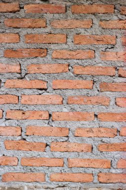 Sıcak toprak tonlarıyla ve yıpranmış detaylarıyla dikey kırmızı tuğla duvar dokusu. Gri harç, kırsal grunge estetiğini artırarak mimari temalar, tasarım planları ve yaratıcı arka plan kullanımı için ideal hale getirir..