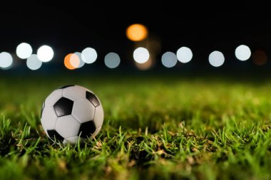 Klasik futbol topu, gece lambalarının altında yemyeşil bir tonda ve mesaj için yeri var. Profesyonel atletizm reklamları, küresel rekabet grafikleri ve sinematik spor pazarlama kampanyaları için ideal.