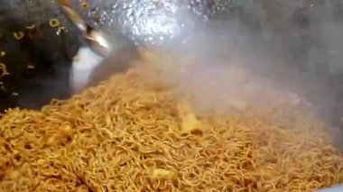 Bitki bazlı Tayland sokak yemekleri hazırlama videosu. Şefin şehriye ve tofuyu doğal buhar efektleriyle sıcak tavaya atmasını izleyin. Sağlıklı, etsiz Asya mutfağı geleneklerini vurgulayan reklamlar için mükemmel..