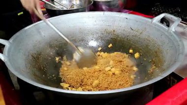 Otantik Tayland sokak yemekleri. Bir satıcı büyük bir tavada tofu ile hazır erişte pişirir, güzel bir buhar ve duman yaratır. Profesyonel pazarlama projelerinde vejetaryen ve Asya mutfağı videoları için mükemmel..