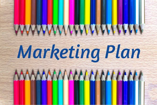 Text Marketing plan on color pencil wood background.