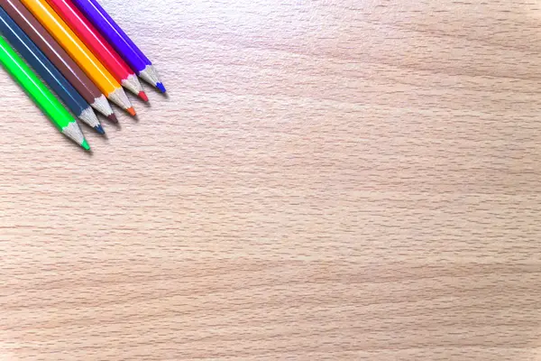 Bir ahşap tahta üzerinde renkli kalemler. — Stok fotoğraf