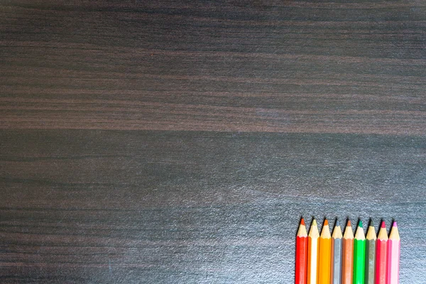 Bir ahşap tahta üzerinde renkli kalemler. — Stok fotoğraf