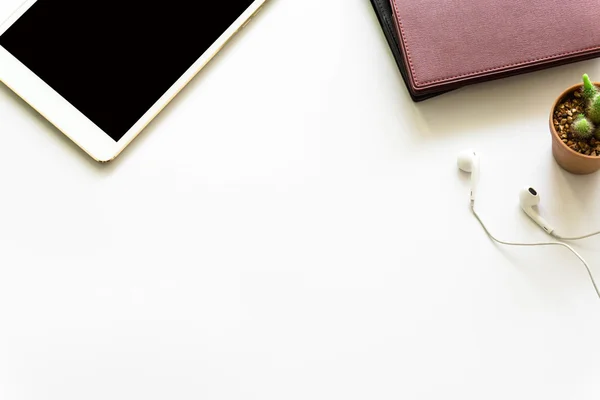 Office desk top view with smartphones, laptop eyeglasses and book.