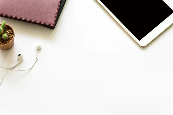 Office desk top view with smartphones, laptop eyeglasses and book.