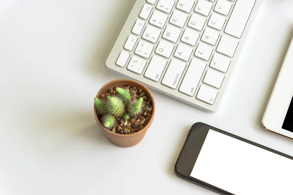 Office desk top view with smartphones, laptop eyeglasses and book.