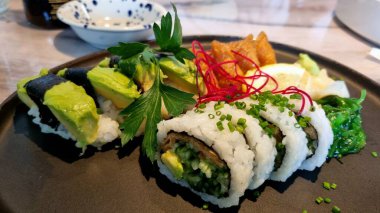 Suşi, pirinç ve soya soslu siyah bir tabakta. Uygun beslenme.