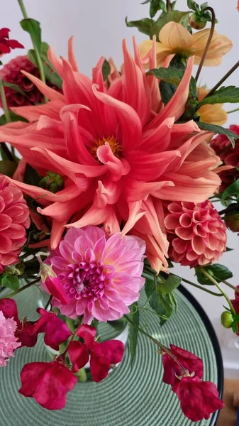 Buket, çiçeklerle arkaplan arasındaki zıtlığı vurgulamak üzere dokuma, yeşil bir vazoya yerleştirilmiş. Kompozisyon, çiçek boyutları ve şekillerinin çeşitliliğini vurguluyor.