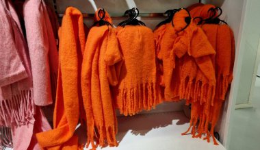 Kış indirimi, turuncu eşarplar ve püsküllü şallar, mağazadaki trempel 'de kışlık kıyafet indirimi.