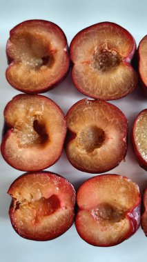 Sulu yuvarlak mavi erikler, koltuk altı, diyet ve düzgün beslenme olmadan ikiye bölünmüş.