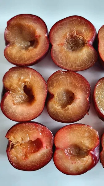 Sulu yuvarlak mavi erikler, koltuk altı, diyet ve düzgün beslenme olmadan ikiye bölünmüş.