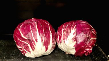 Salatalar için kırmızı lahana, siyah arka planda beyaz damarlı kırmızı lahana. Uygun beslenme ve diyet