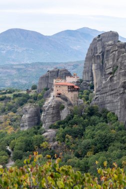 Tarihi bir manastır dik bir uçurumun tepesinde duruyor, taş mimarisini dramatik doğal jeolojiyle harmanlıyor..