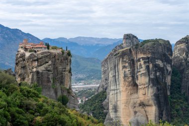 Meteora 'daki bir ormanlık vadiden yükselen yüksek bir kaya oluşumu