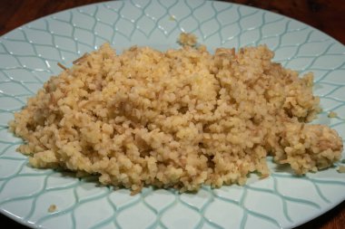 Bir porsiyon vermicelli bulgur pilavı açık mavi desenli bir tabakta oturur..