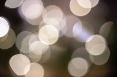 Yumuşak beyaz bokeh ışıklar bulanık doğal bir arkaplanda parıldıyor