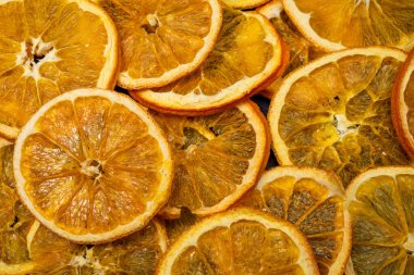 Kurutulmuş portakal dilimleri, kurutulmuş posa ve altın kabukların detaylı dokusunu gözler önüne seriyor..