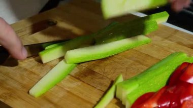 Büyük, beyaz kaplamalı yeşil dalgalar sisli bir kış gökyüzünün altında karanlık, kayalık bir sahile çarpıyor..