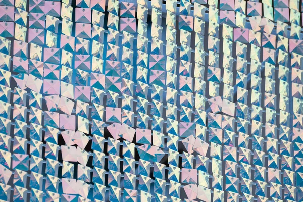 Yanardöner gümüş, mavi ve pembe tonlarda parıldayan binlerce küçük, kare yansıtıcı panelle kaplı kinetik bir cephe..