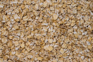 Çiğ yulafların pürüzlü, pürüzlü dokusu, açık bej ve kremsi beyaz tonlarıyla manzarayı dolduruyor..