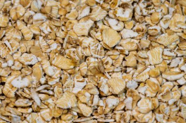 Çiğ yulafların pürüzlü, pürüzlü dokusu, açık bej ve kremsi beyaz tonlarıyla manzarayı dolduruyor..