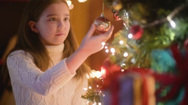Ευτυχισμένο Κοριτσάκι Στολίζει Χριστουγεννιάτικο Δέντρο Μπάλες Πολλά Κουτιά Δώρων Κάτω — Αρχείο Βίντεο