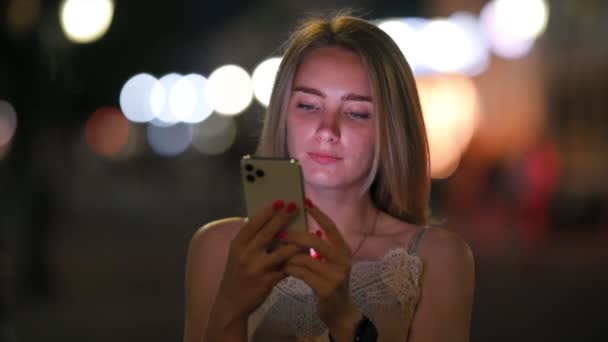 Söt Flicka Använder Smartphone Och Leenden Stående Night Street Staden — Stockvideo