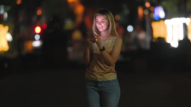 Menina Bonito Usa Smartphone Sorrisos Rua Noite Cidade Mulher Mensagens — Vídeo de Stock