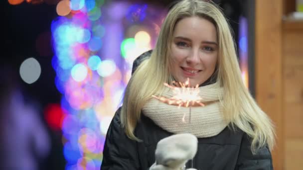 Chica Joven Feliz Quema Chispas Fondo Una Feria Navidad Festiva — Vídeo de stock