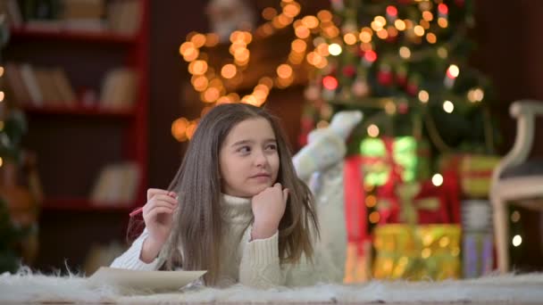 Portret Uroczej Dziewczynki Leży Podłodze Pisze List Świętego Mikołaja Tle — Wideo stockowe