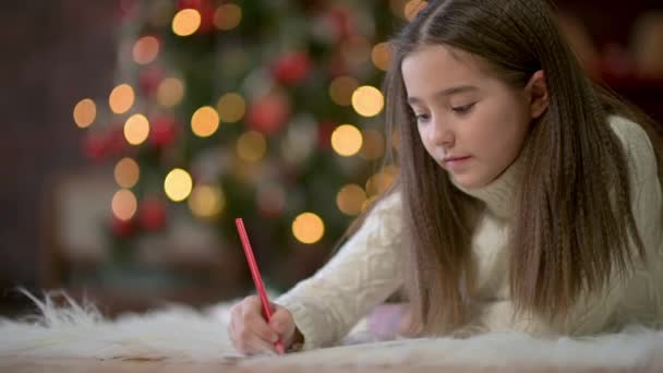 Portret Uroczej Dziewczynki Leży Podłodze Pisze List Świętego Mikołaja Tle — Wideo stockowe
