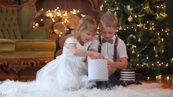 Gelukkige Kleine Kinderen Zitten Vloer Buurt Van Kerstboom Opent Geschenken — Stockvideo
