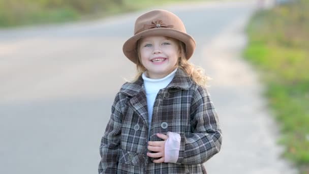 Paltolu Şapkalı Şirin Küçük Kız Çayırda Yürüyor Gülüyor Kameraya Bakıyor — Stok video