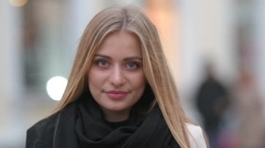 Poltoyla gezen mutlu genç bir kızın portresi ve şehirdeki sokakta gülümseyen ve kameraya bakan bir eşarp. Yaşam biçimi.