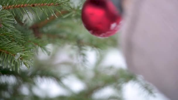 Kvinnors Händer Vantar Hänger Juldekorationer Grangren Snöigt Nyårsträd God Jul — Stockvideo