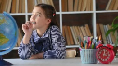 Genç Latin kökenli ilkokul öğrencisi bir masada oturup, ödevlerini yapıyor. Evden Öğrenci Kız Çalışması