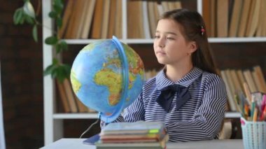 Öğrenci Çocuk Kütüphanede Dünya Küresi okuyor. Okul sınıfındaki çocuk